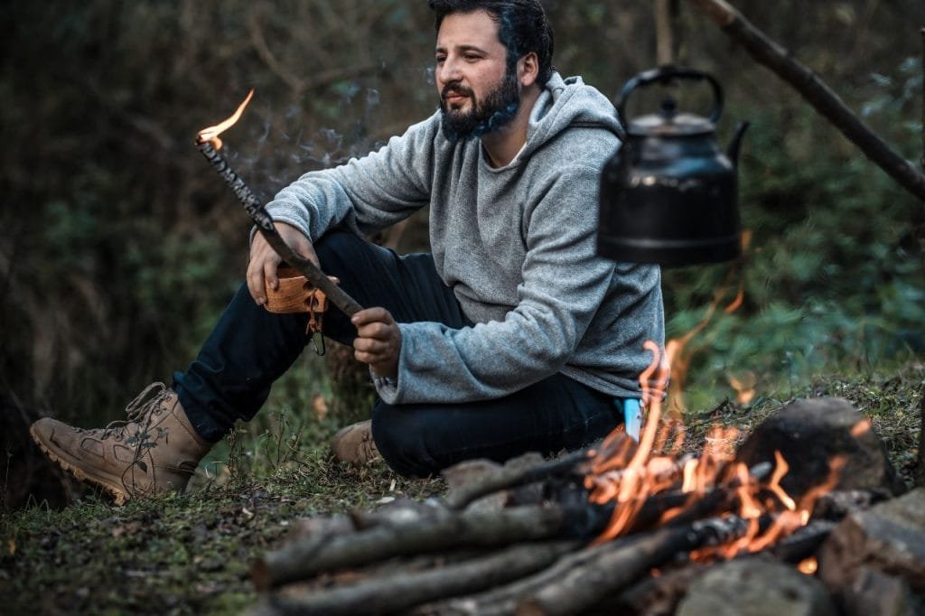 Fotografia de homem ao lado da fogueira - Bushcraft