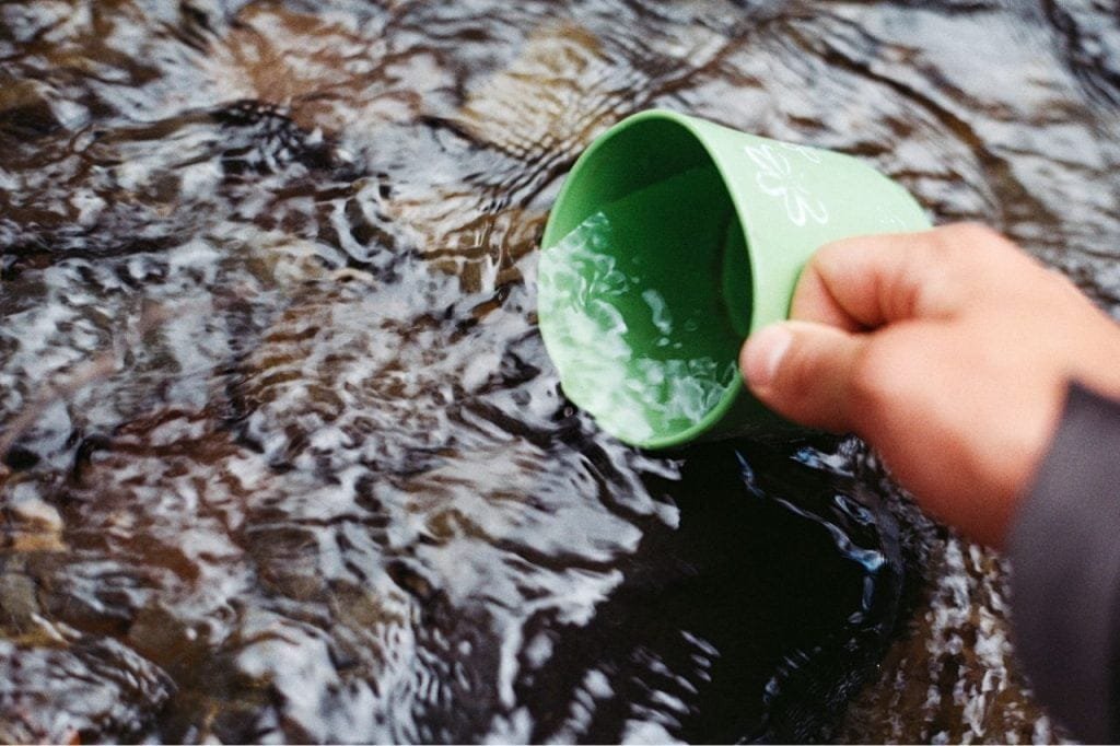 Imagem caneca na água de rio, Bushcraft